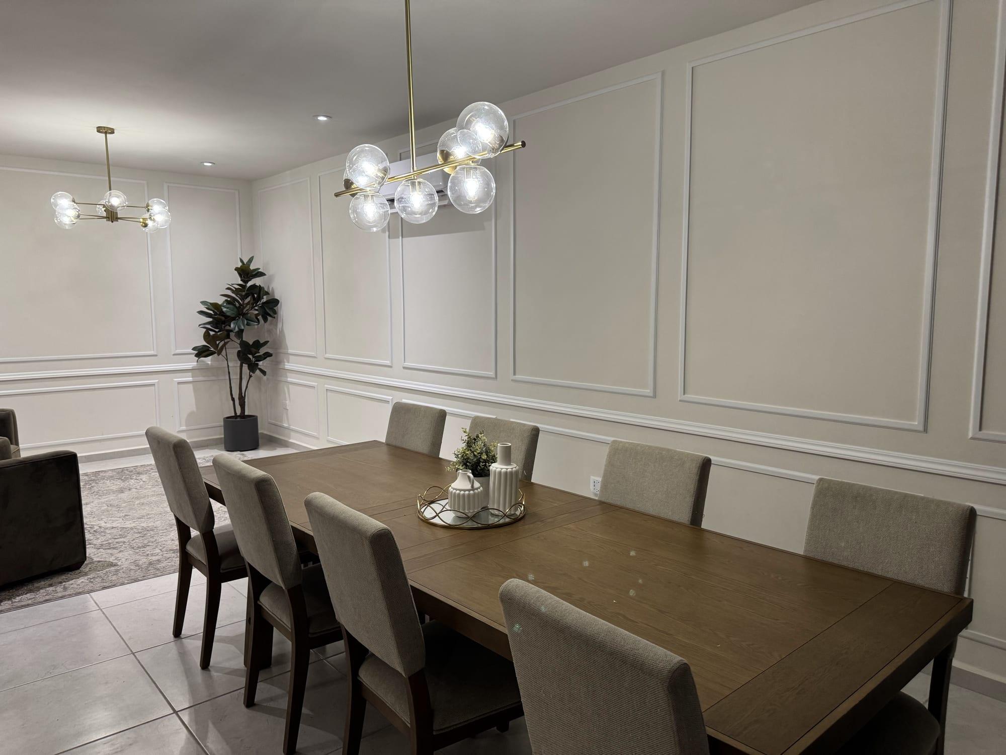Comedor con boiserie y molduras decorativas en las paredes